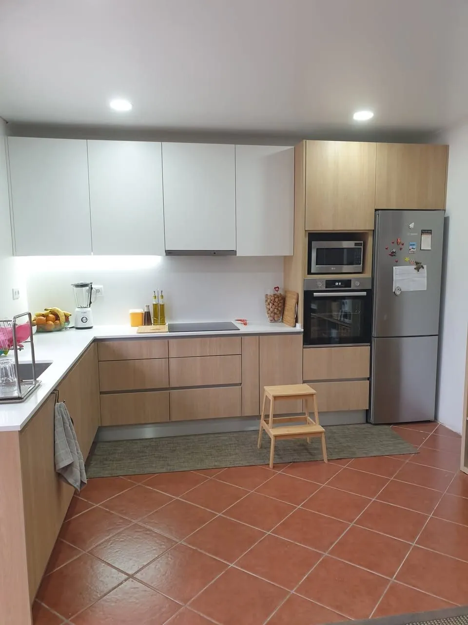 Cozinha em madeira e branco com eletrodomésticos encastrados