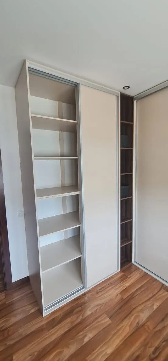 Roupeiro de portas de correr aberto com prateleiras